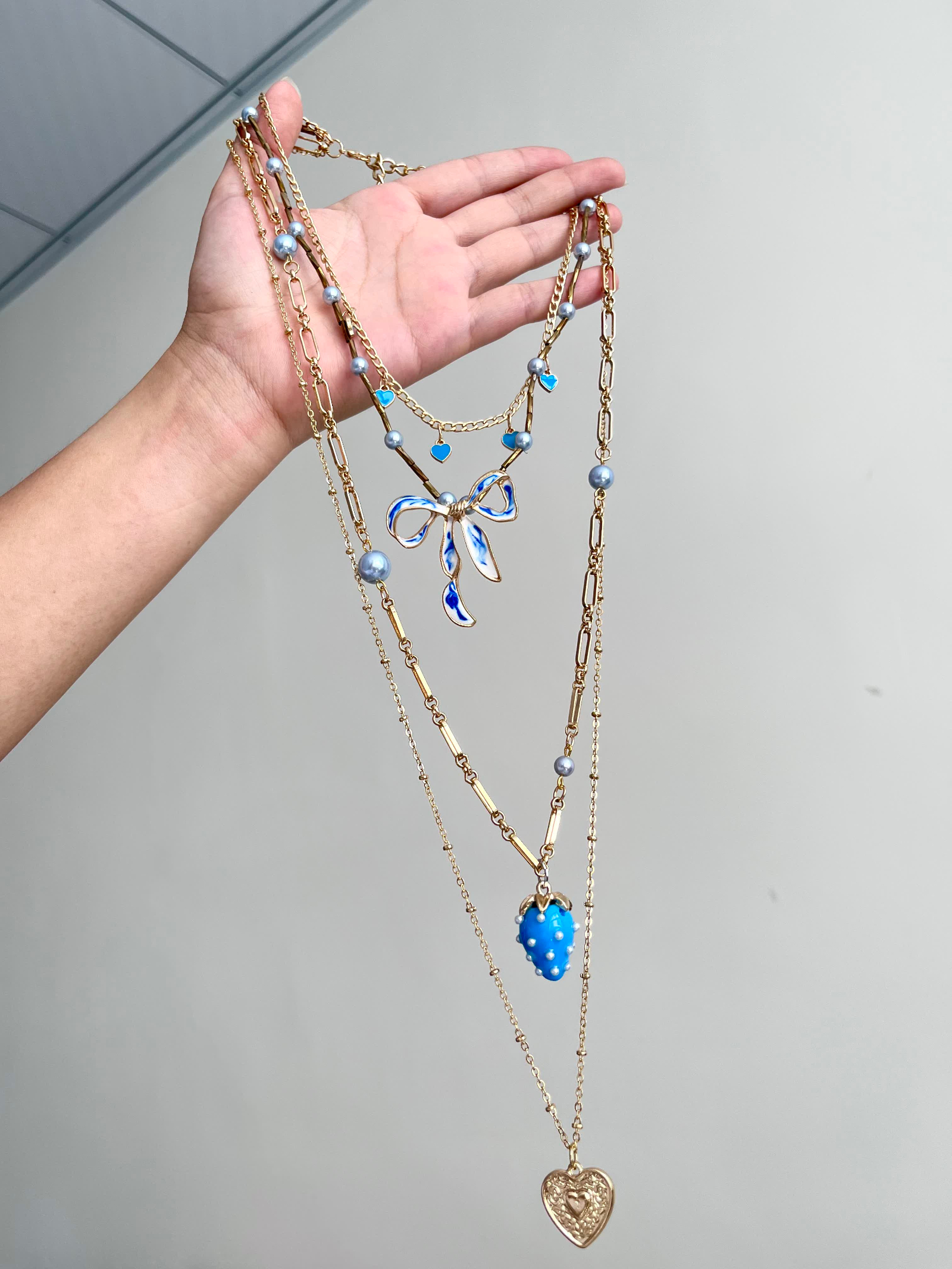Blue bow and strawberry charm layered necklace